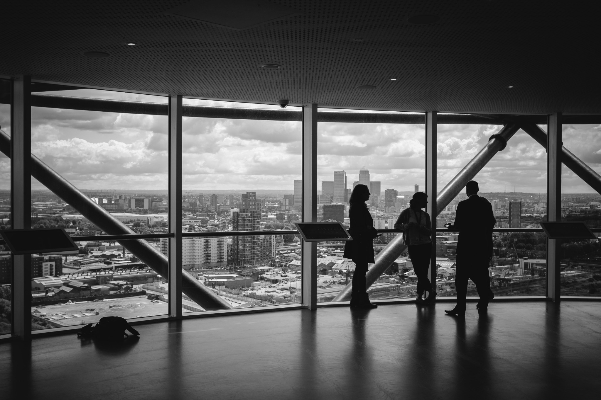 Business silhouettes in front of large windows overlooking a financial district