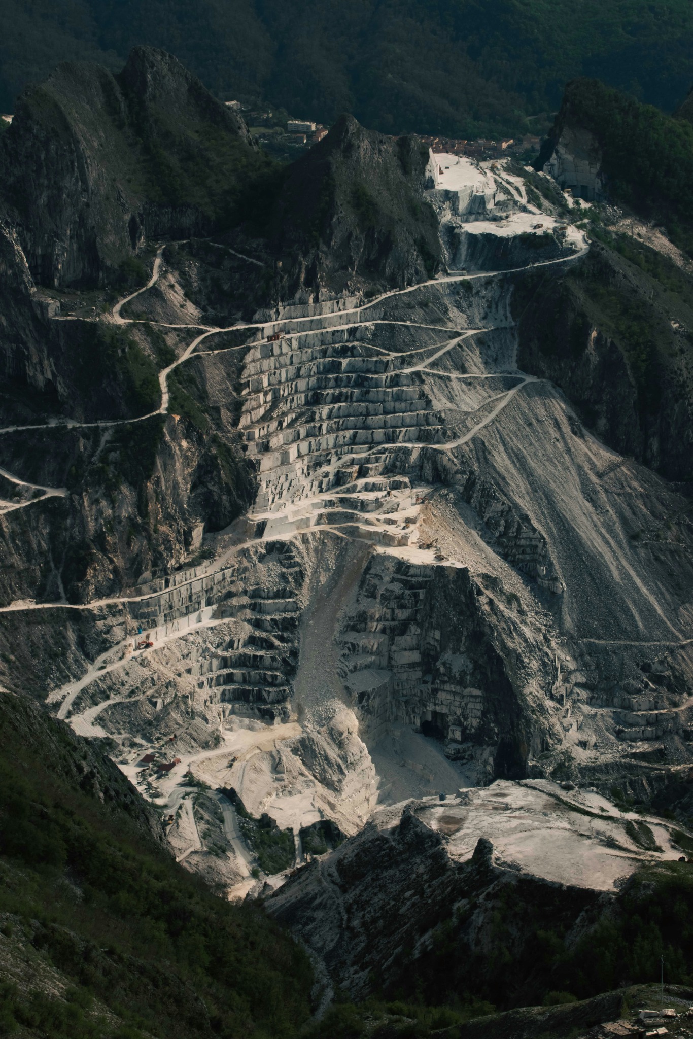 Large open quarry cut into a mountainside